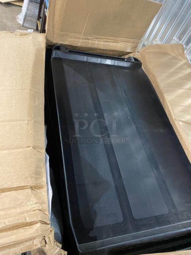 Brand new Rubbermaid Commercial black 3-tier utility cart with casters, partially in box, showing durable construction.