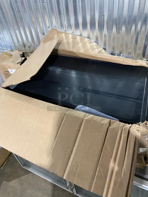 Brand new Rubbermaid 3-tier utility bus cart in original packaging, featuring black open-sided design with casters.