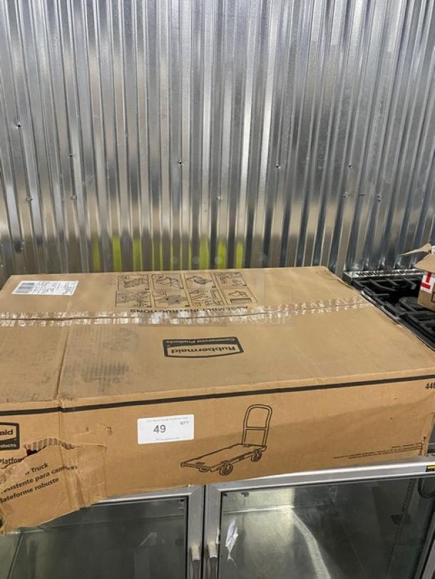 Rubbermaid Commercial platform truck, model FG440300BLA, in original box. Features 24"x36" size, single handle, 5" casters.