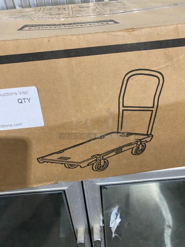 Rubbermaid Commercial black platform truck, model FG440300BLA, 24"x36", with single handle and 5" casters, in original packaging.