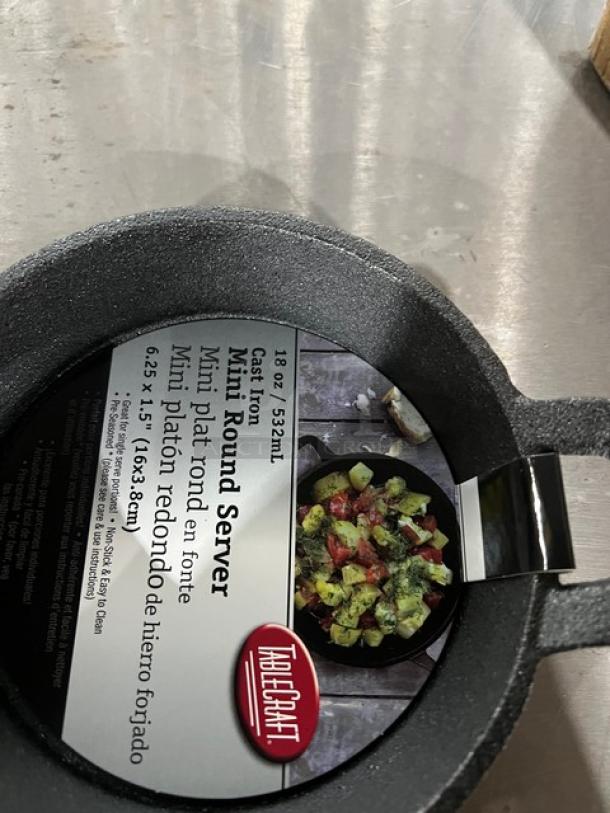 Brand new TableCraft CW30142 mini cast iron server, 18 oz, round, pre-seasoned, black, with label detailing size.