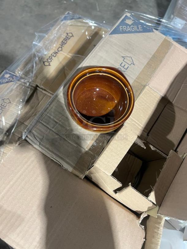 Mixed pallet featuring commercial kitchen items in boxes. Brown ceramic bowl atop boxes marked "Fragile" and "Open Here."