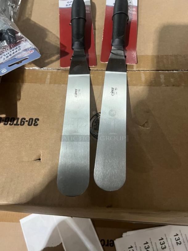 Brand new Winco Winware TKPO-9 stainless steel 8.5"x1.5" offset spatulas with black grip handle, on display packaging.