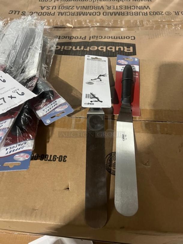 Brand new Winco TKPO-9 offset spatula, 8-1/2"x1-1/2", stainless steel with black grip handle, in packaging.