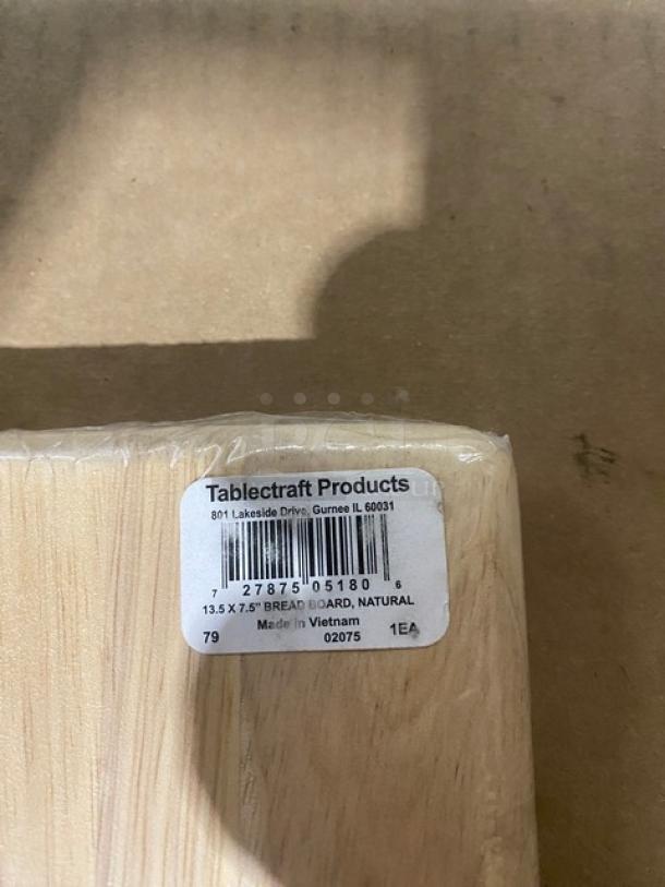 Brand new TableCraft Model 79 wooden bread board, 13.5"x7.5", natural finish, wrapped in plastic with product tag visible.