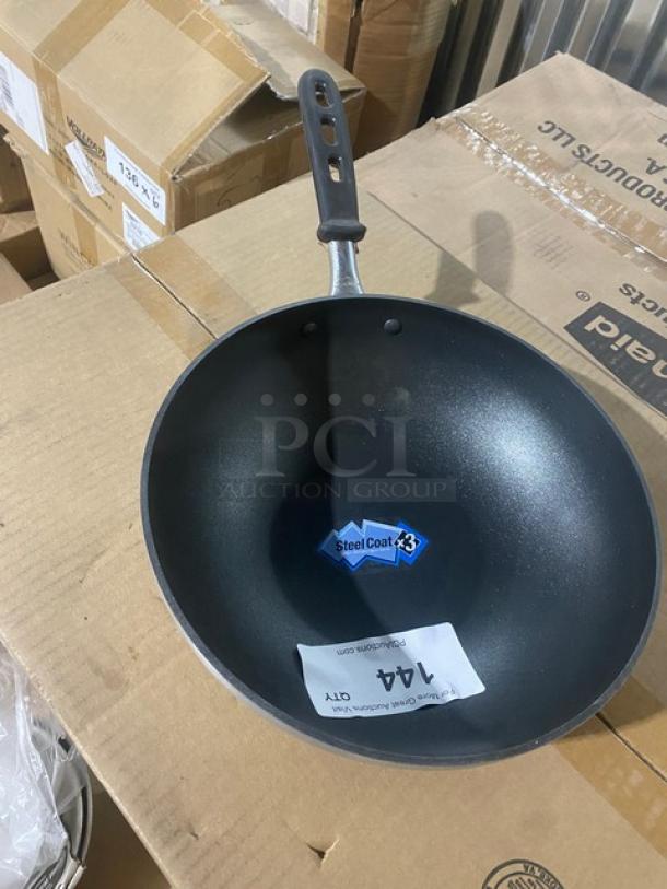 Vollrath 11" stir fry pan, model 68120, brand new, non-stick aluminum with Steel Coat x3, black grip handle visible.