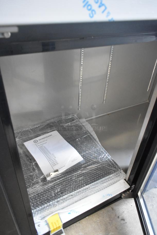 Brand new 2022 Hoshizaki BB95-G commercial 3-door back bar cooler. Interior view shows shelves and a packet with brand label.