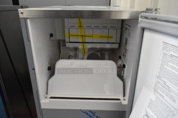 Brand new Hoshizaki AM-50BAJ-DS commercial icemaker, 115 volts, 1 phase, with shipping tape and instructions visible.