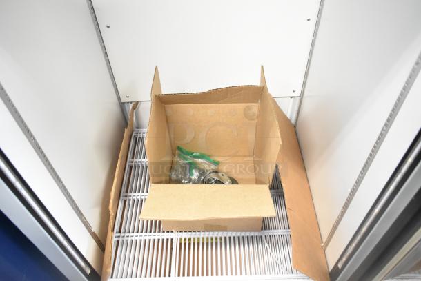 Brand new 2023 Hoshizaki RM-26-HC-L commercial reach-in cooler interior with box containing casters. 115 Volts, 1 Phase.