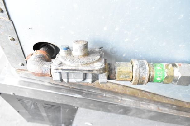 Rusted pipe connection of BT60-4N Commercial Gas Powered 4 Burner Range, showing gas regulator and fittings.