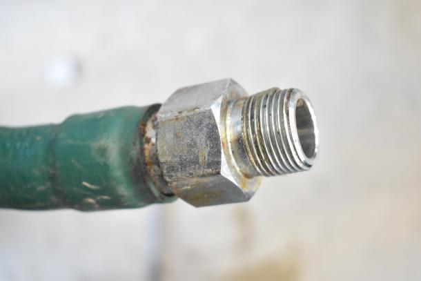 Close-up of a threaded metal gas connector, likely part of the BT60-4N Commercial Gas Powered 4 Burner Range. Condition shows signs of wear.