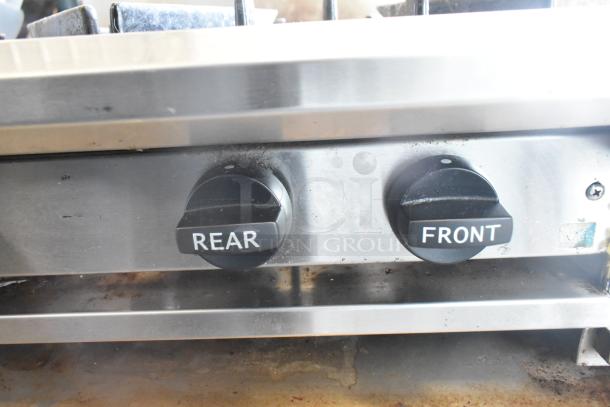 BT60-4N commercial gas range knobs labeled "Rear" and "Front," stainless steel surface, showing signs of use.