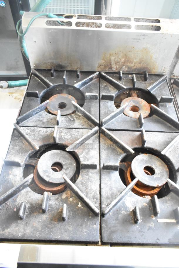 BT60-4N Commercial Gas 4 Burner Range, showing signs of use. Model BT60-4N, ideal for high-capacity cooking.