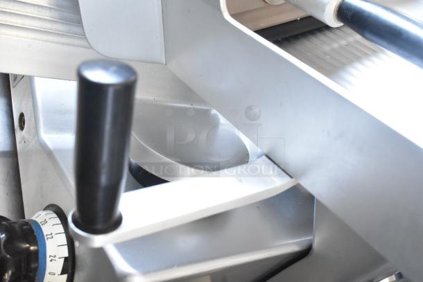 Bizerba SE 12 US commercial meat slicer with blade sharpener, shown close-up. Features dial for thickness adjustment. 120V, 1 Phase.