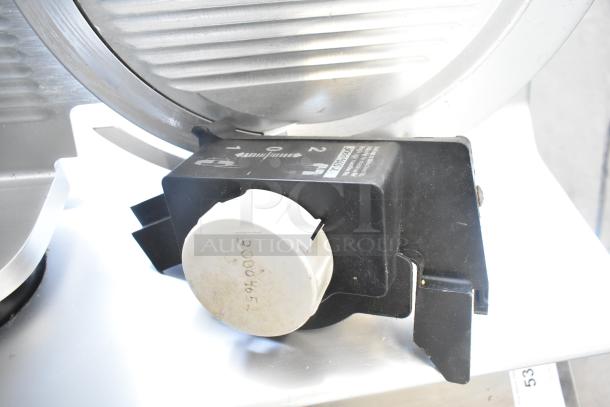 Bizerba SE 12 US meat slicer with blade sharpener, 120V, 1 phase. Black control knob and markings visible on housing.