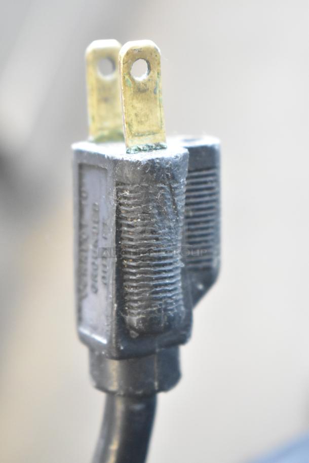 Close-up of a 120V plug from a Bizerba SE 12 US commercial meat slicer, showing signs of wear.