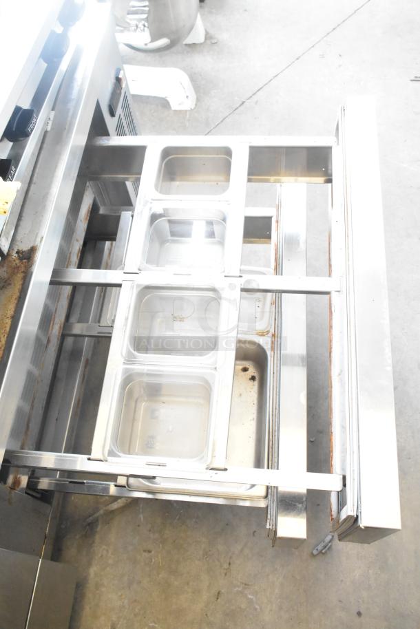 Coldline CB-72 commercial 4 drawer chef base; stainless steel, on commercial casters. Visible interior with storage pans.