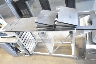 Commercial double pan rack with shelves, sturdy metal frame, commercial casters for mobility, in excellent condition.