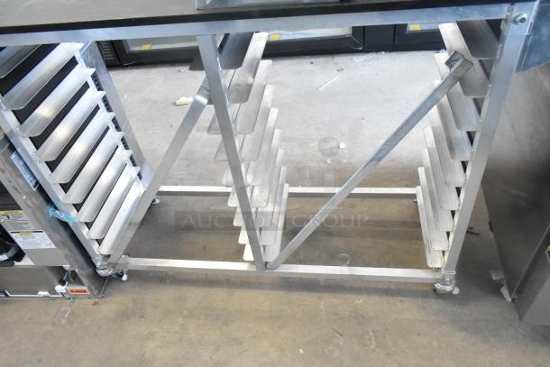 Commercial double pan rack on commercial casters, metal frame, multiple pan slots, used condition, mobility for easy transport.