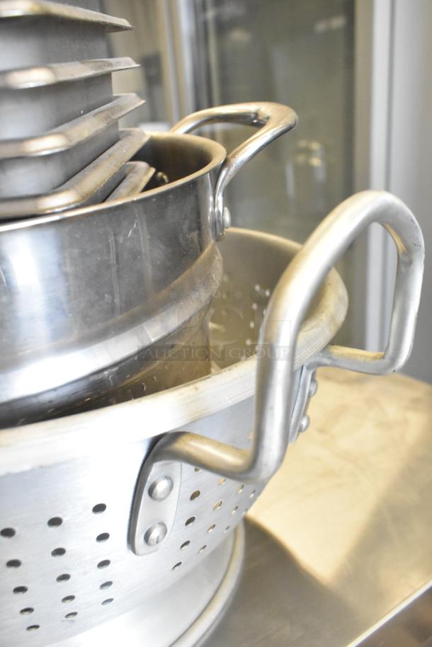 Stainless steel colander with handles, part of 47-item auction including drop-in bins. Excellent condition.