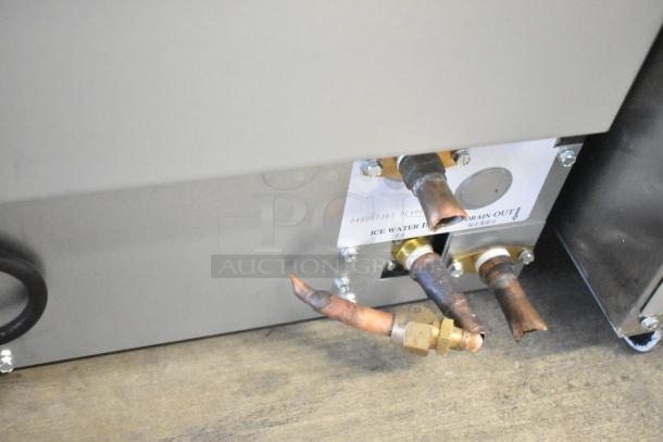 Manitowoc UYF0140A-161B ice machine connections, showing copper pipes and labeling for water inlet and drain.