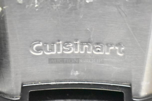 Close-up of Cuisinart juicer base with embossed brand logo, stainless steel finish, showing minor wear.