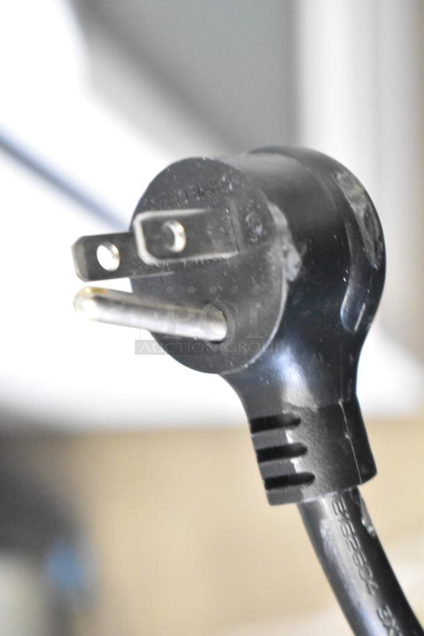 Close-up of a black, three-prong electrical plug for the 2021 True TSCI-600R-G-PH cooler, 115 volts, 1 phase.