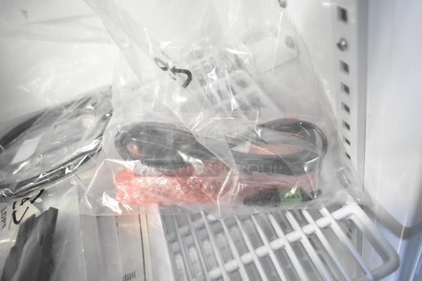 Accucold ARG3PV456 commercial mini cooler interior showing shelves and accessories in original packaging.