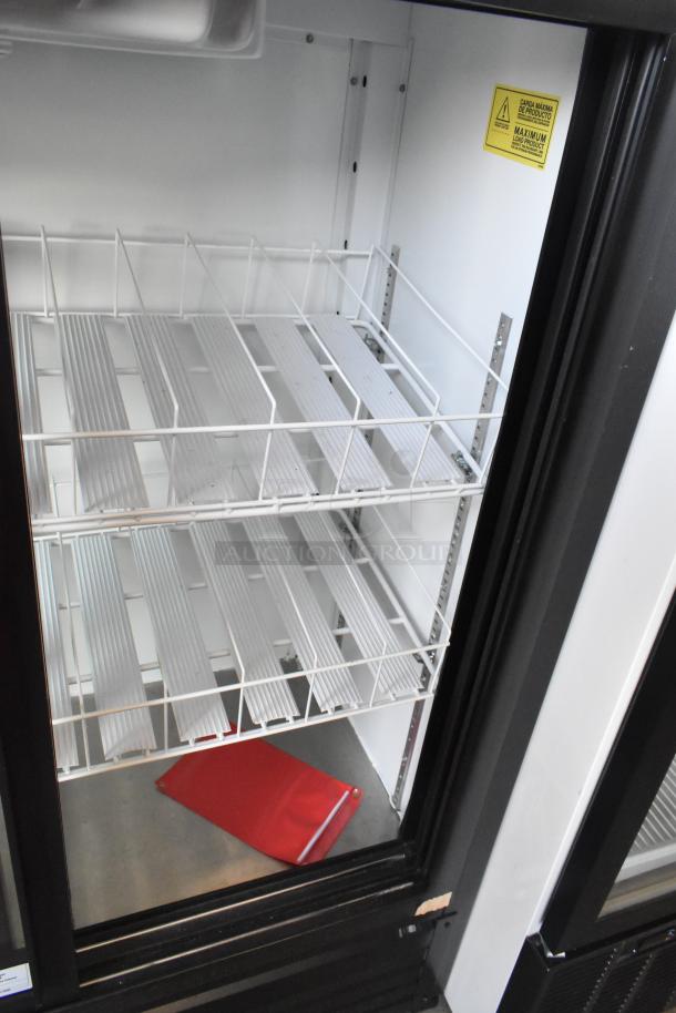 Imbera VRD41 commercial 2-door reach-in cooler, clean interior with adjustable wire shelves, visible caution label.