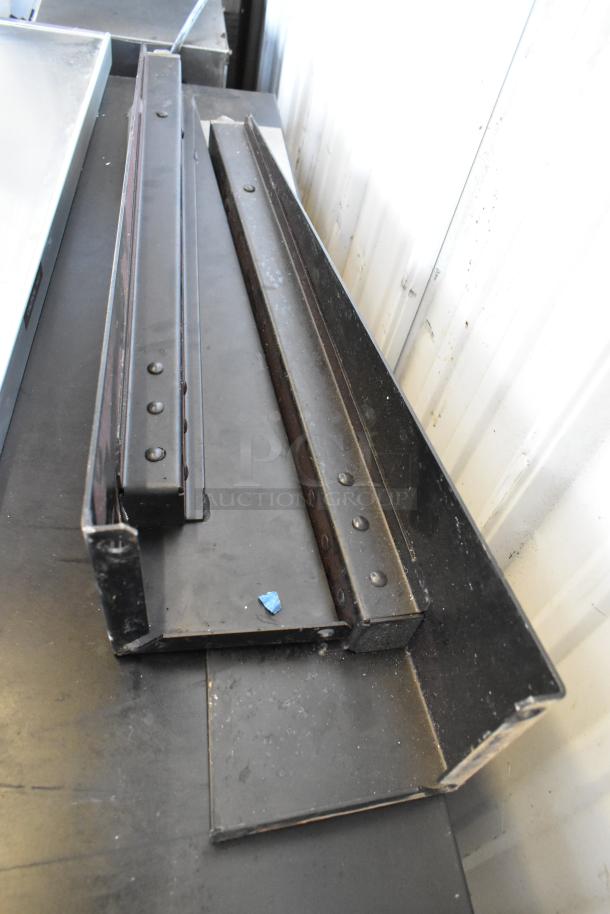 Black metal components on a table, possibly parts for a Duke convection oven. No visible markings or labels.