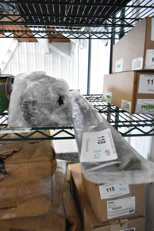 2 BRAND NEW SCRATCH AND DENT items, including TR36 Ticket Rack, Delfield 3516298 Evaporator Coil, in warehouse. Tags indicate model numbers and auction details.