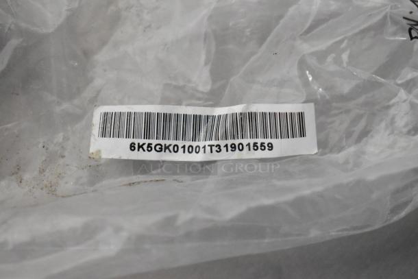 Clear plastic bag with barcode label "6K5GK01001T31901559". Contains a handle and two connectors. New scratch and dent condition.
