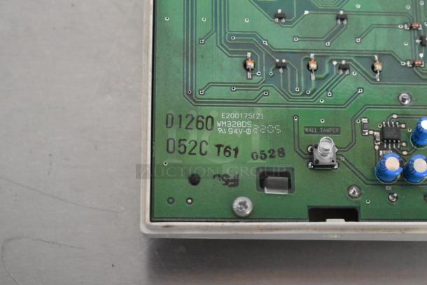 Circuit board with printed markings: "E200175(2) WM328DS RU 94V-0" and labels like "WALL TAMPER," featuring various electronic components.
