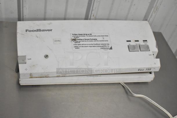 FoodSaver Vac750 vacuum bag sealer, white, slight wear, includes original box. Features lock mechanism, labeled controls.
