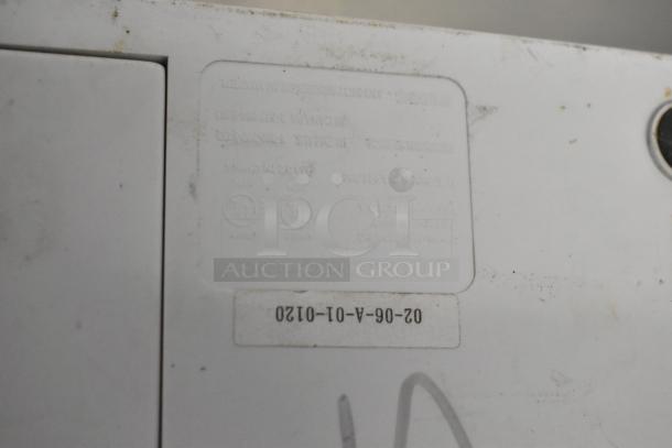 Close-up of the Food Saver Vac750 Vacuum Bag Sealer showing a label with model and serial number details on the unit's surface.