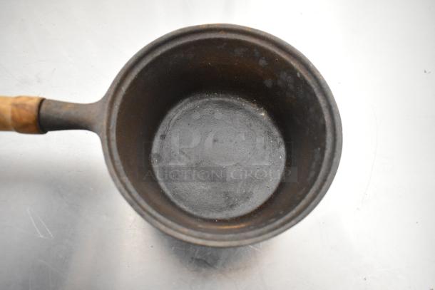 Vintage metal pan with wooden handle, showing signs of wear, part of a 2-item auction set including a black poly bin.