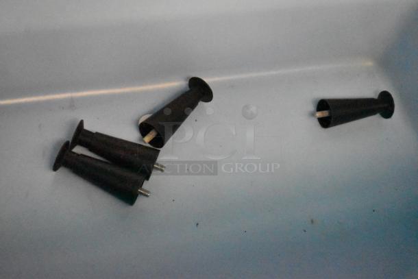 Black plastic conical components on a light surface, likely parts from a commercial appliance. Condition appears used.