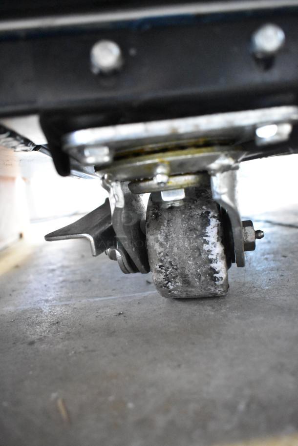 Close-up of commercial caster wheel attached to the 2020 True TG2R-2S-HC stainless steel reach-in cooler.