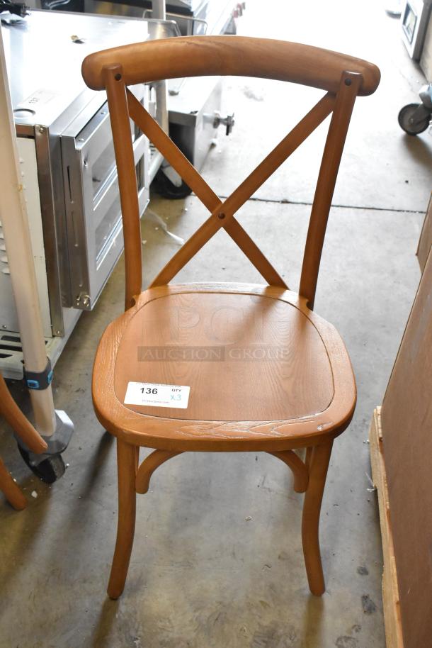 Wooden dining chair with curved backrest and X-shaped support. Light wood finish, shown in good condition. Tag indicates quantity of three chairs.