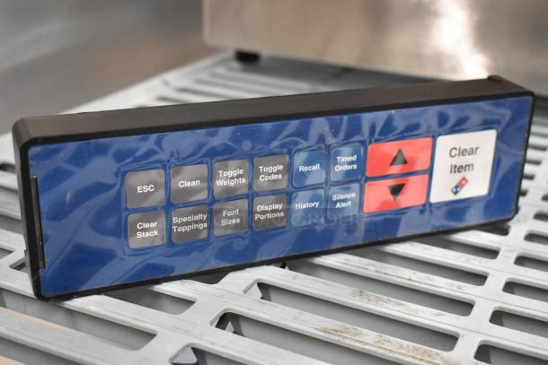 Blue and black control panel with multiple buttons, including ESC, Clean, Toggle Weights, and Clear Item. Slight surface wear visible.