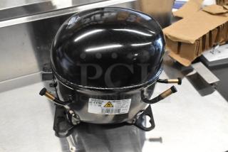 Brand new Embraco NEX4170UA compressor with minor scratches. 115-127 volts, 1 phase. Labels indicate model and specs.