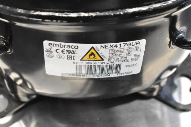 "Brand new Embraco NEX4170UA compressor, 115-127V, 1 phase. Scratch and dent, thermally protected. Label shows model, specs."