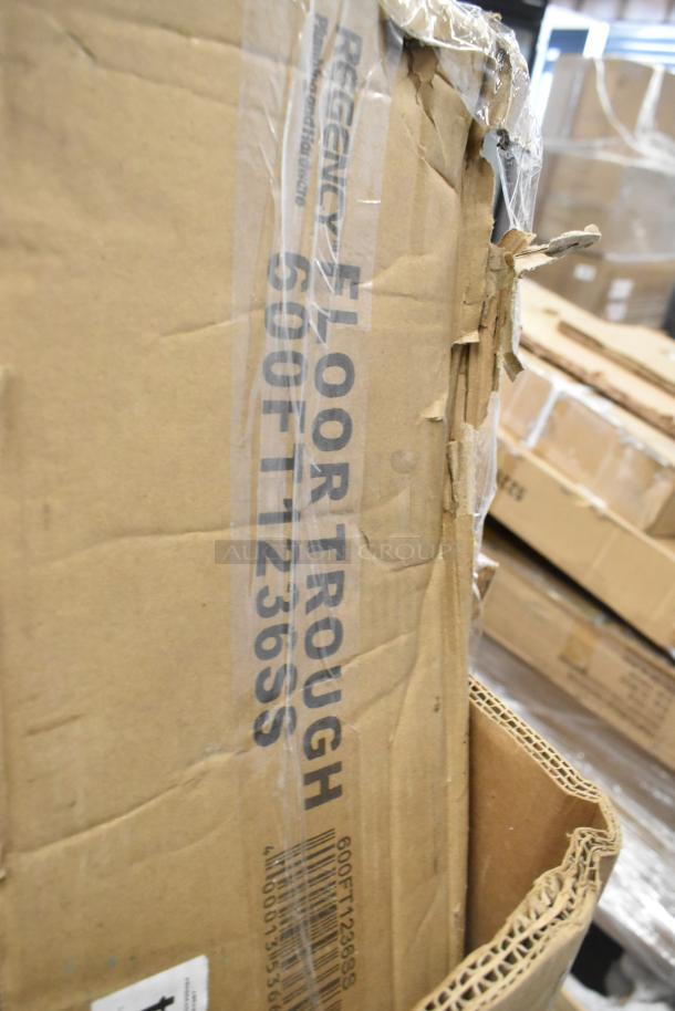 Cardboard box labeled "Regency Floor Trough 600FT1236SS." New condition with visible scratches and dents.