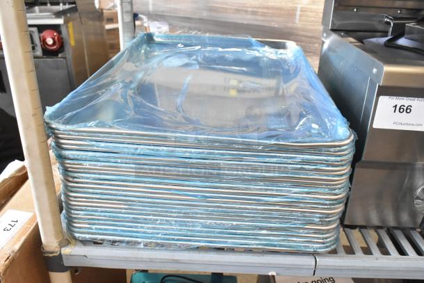 Stack of 25 brand new Vollrath 5315 and Choice 18"x26" aluminum bun pans on shelf, wrapped in blue protective film.