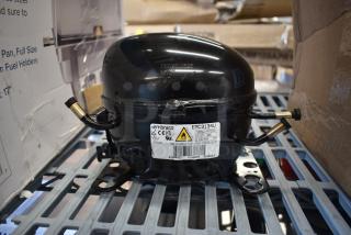 BRAND NEW Embraco EMC3134U compressor for various models; 115V, R-290. Scratch and dent condition. Visible label details specs.