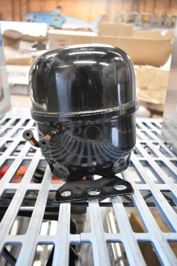 Brand new Cubigel NUT55NR compressor, minor scratches, compatible with Avantco models, sturdy black casing.