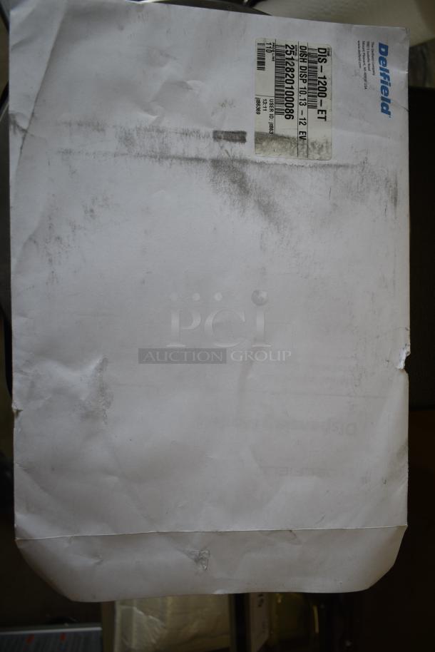 Crinkled paper with smudges and a Delfield label showing product details and numbers. Label specifies "DIS-1200-ET."