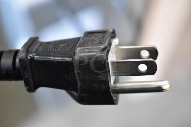 Close-up of a black electrical plug for the Rinnai SENSEI RX199iN tankless water heater, showing prongs and some wear.