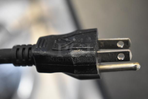 Close-up of a black electrical plug with minor scratches, part of a 2025 Bunn ICB-DV BrewWISE coffee brewer.