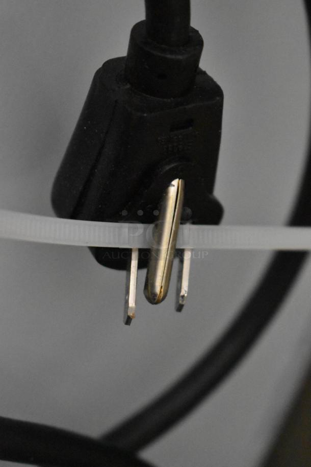 Close-up of a power plug for the Scotsman HID525AB-1A ice machine, showing prongs and cord tied with a zip tie.